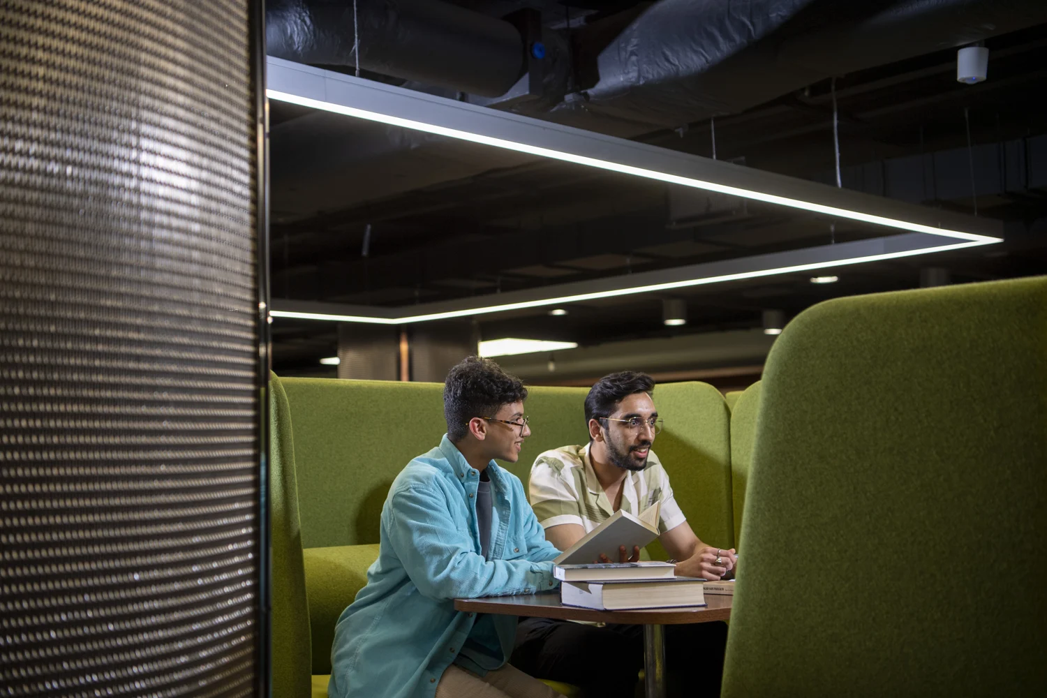 Keshav reading with a fellow student in the university library